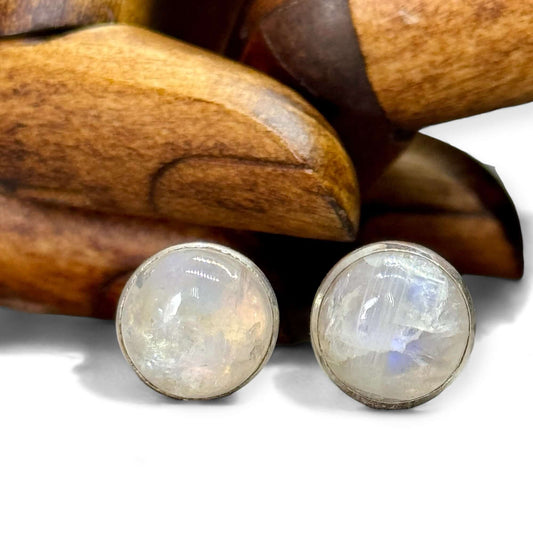 A pair of sterling silver stud earrings with a round rainbow moonstone cabochon in each.