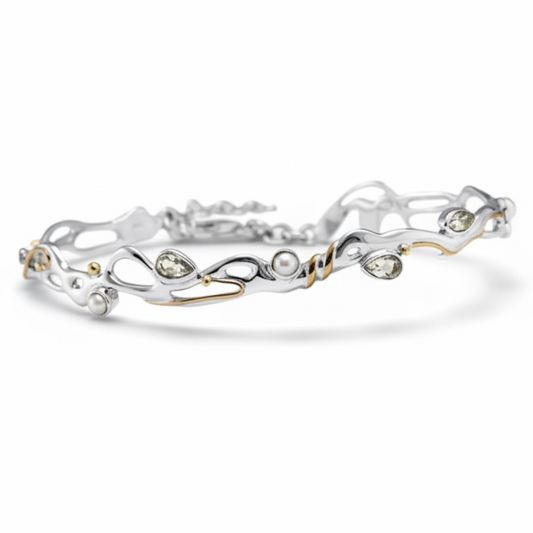 Green amethyst and pearl sculptural bracelet in sterling silver with gold accents on white background