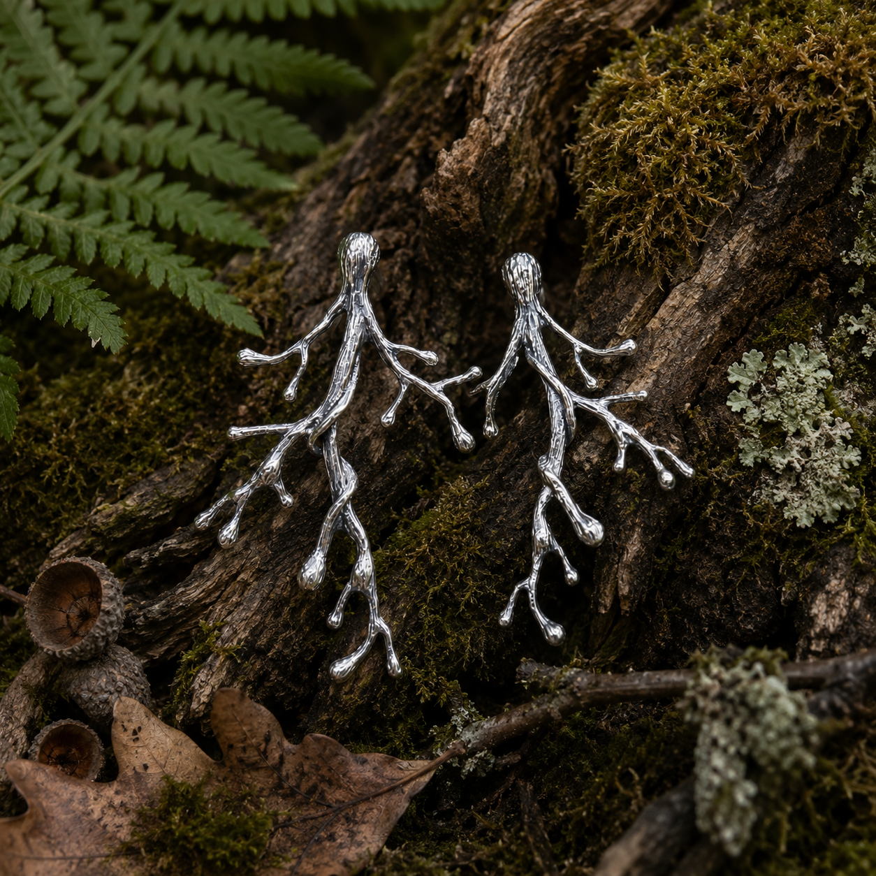 Ancient Woodland Branch Earrings handcrafted in sterling silver displayed amongst moss, tree roots, ferns and woodland textures