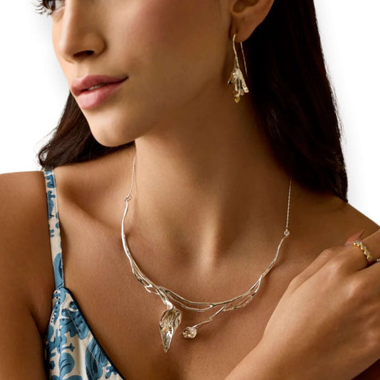 Model wearing Calla Lily sculptural sterling silver statement necklace with gold detail - Twelve Silver Trees