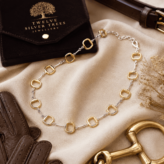 Luxury sterling silver and 18ct gold snaffle necklace styled with leather riding glove and velvet jewellery wallet