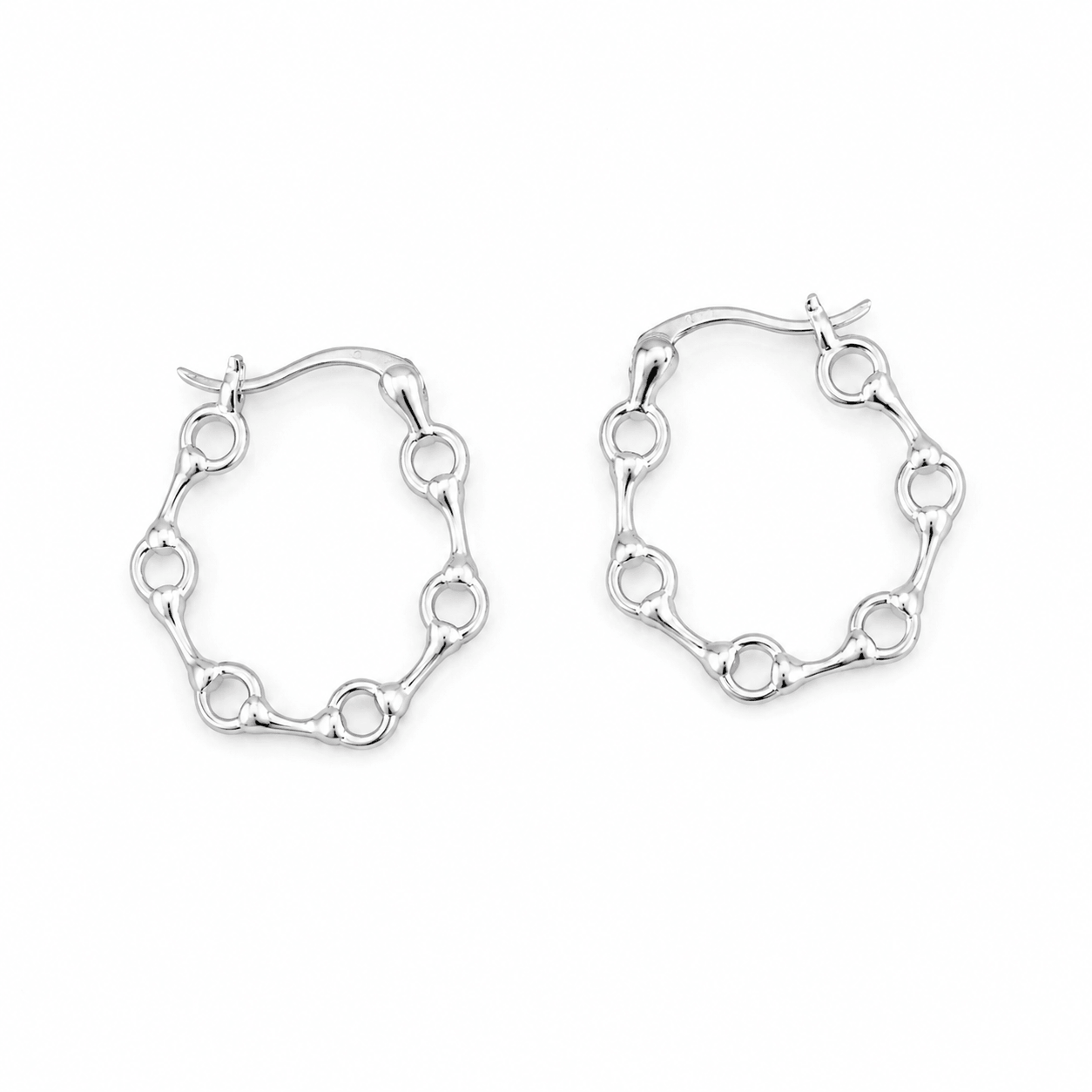 Sterling silver snaffle hoop earrings arranged in a clean flat lay on a soft white background