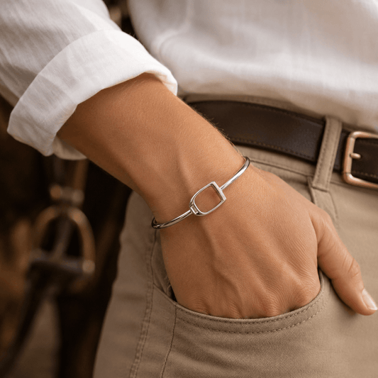 Handcrafted sterling silver stirrup bangle worn on wrist with elegant equestrian-inspired styling