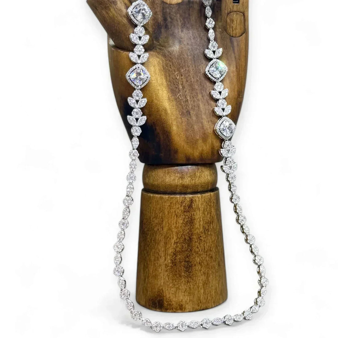 Image of Twelve Silver Trees Jewellery handmade sterling silver Art Deco Styled necklace displayed on a dark wooden artists model hand on a white background 