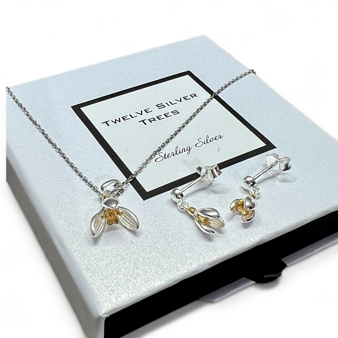 Cover picture for Twelve Silver Trees Jewellery & gifts blog post. Image of a black and white match box style jewellery box with our handmade sterling silver & 18 carat gold vermeil snow drop earrings and pendant.