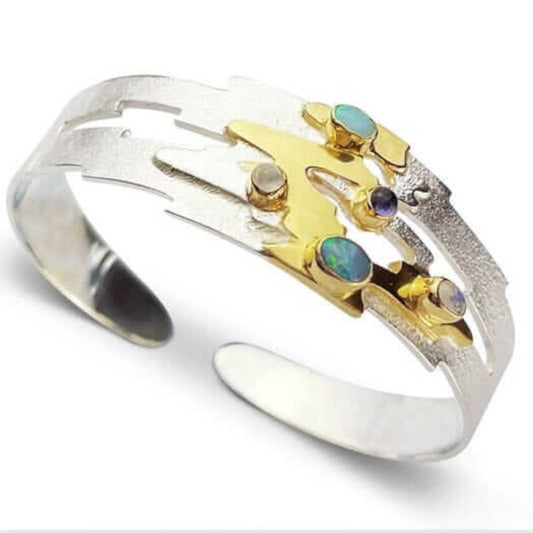 Handmade sterling silver cuff bangle with 18 carat gold accents set with opals, moonstones & amethyst by Paul’s Bolton from the Monet reflections jewellery range available;e from Twelve Silver Trees Jewellery 