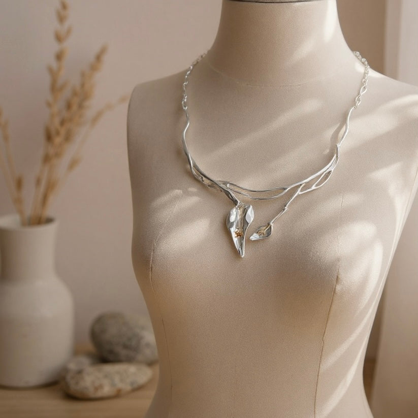 Image of Twelve Silver Trees Statement lily necklace, handmade in sterling silver, displayed on a cream linn mannequin 