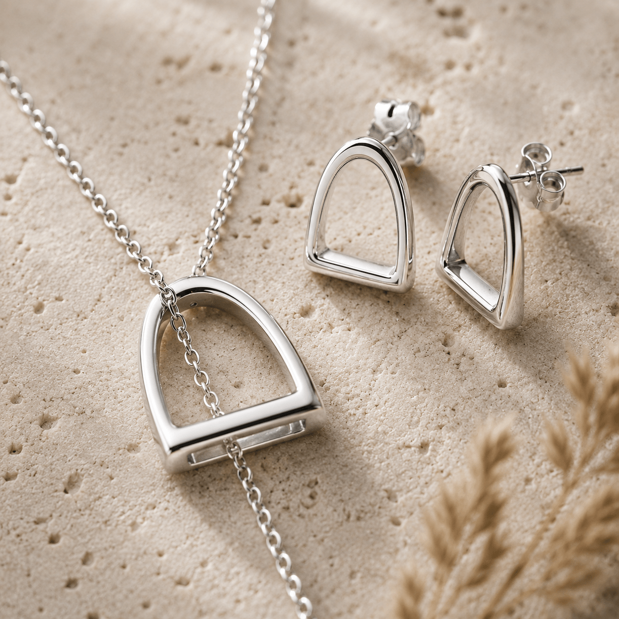 Collection image for the twelve silver trees Equestrian collection featuring sterling silver stirrup necklace and earrings and a natural stone background 