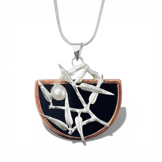 Sterling silver Jewelry pendant with black background, silver branches, and pearl on a white background