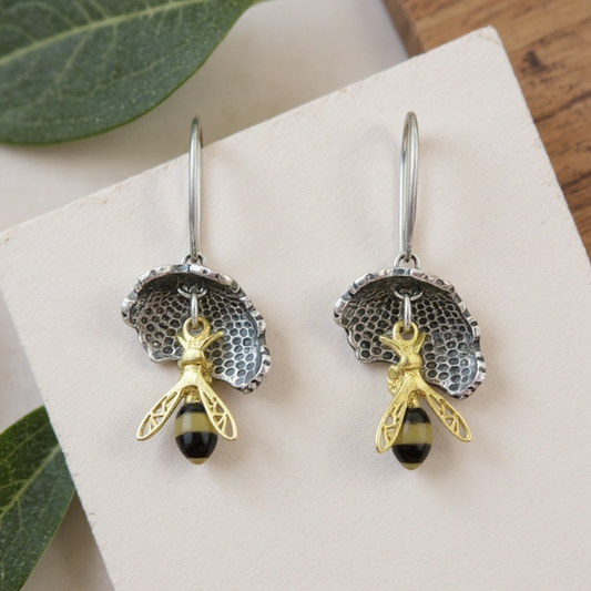 Handmade sterling silver bee earrings with baltic Amber bodies and gold plated wings suspended from concave honeycomb in pierced silver with lever back fittings from the bee collection at Twelve Silver Trees Jewellery 
