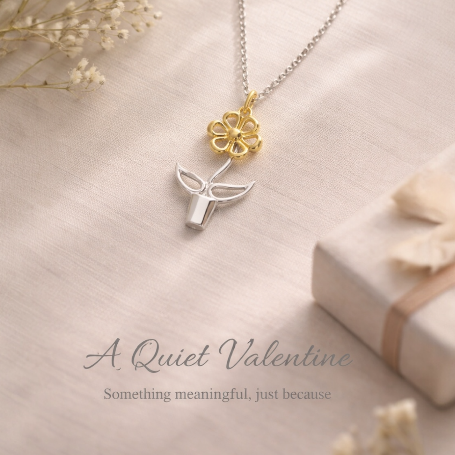 Necklace with a gold flower and silver flower in a plant pot pendant on a soft beige background with 'A Quiet Valentine, So etching meaningful , Just because’ text.