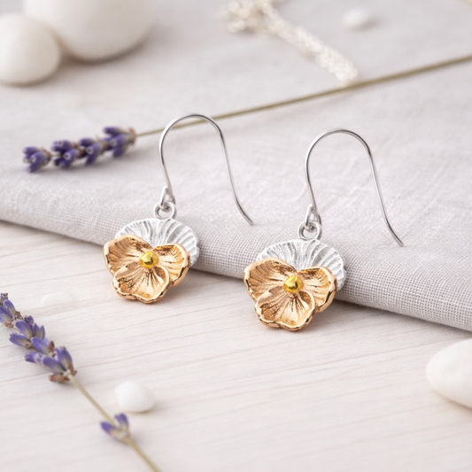 Pair of handmade violet flower earrings with hook fittings. floral earrings with rose gold and silver design on a natural background from Twelve Silver Trees Jewellery 