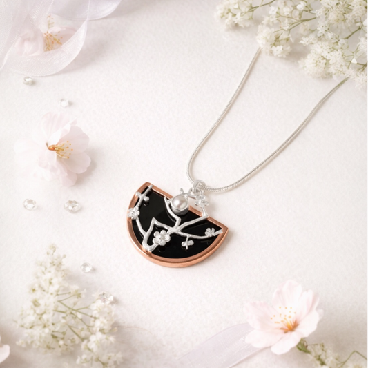 Sakura cherry blosdom Necklace with a black and rose gold pendant on a white background with flowers from the herbarium collection 