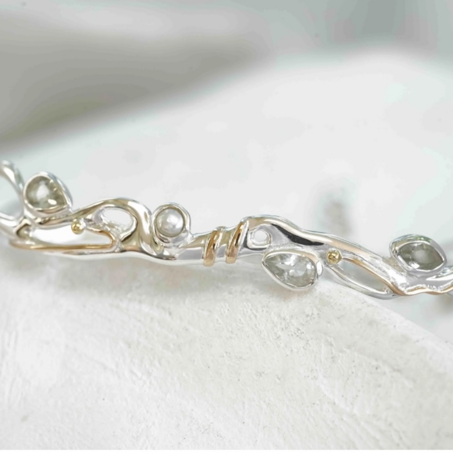 Close up of green amethyst and pearl bracelet with gold accents in sterling silver, sculptural Sunlit Earth design