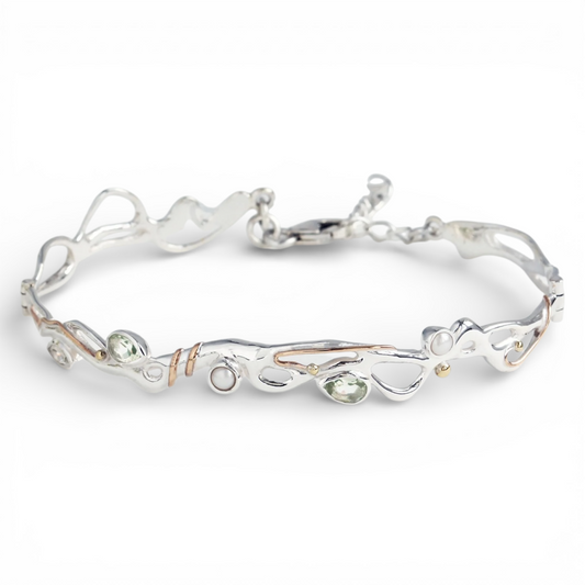 Green amethyst and pearl sculptural bracelet in sterling silver with gold accents on white background