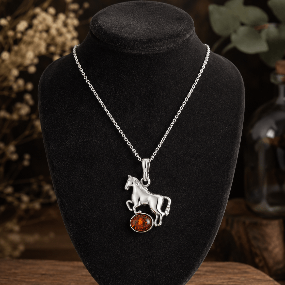 Sterling silver and amber horse pendant necklace displayed on a black velvet jewellery bust