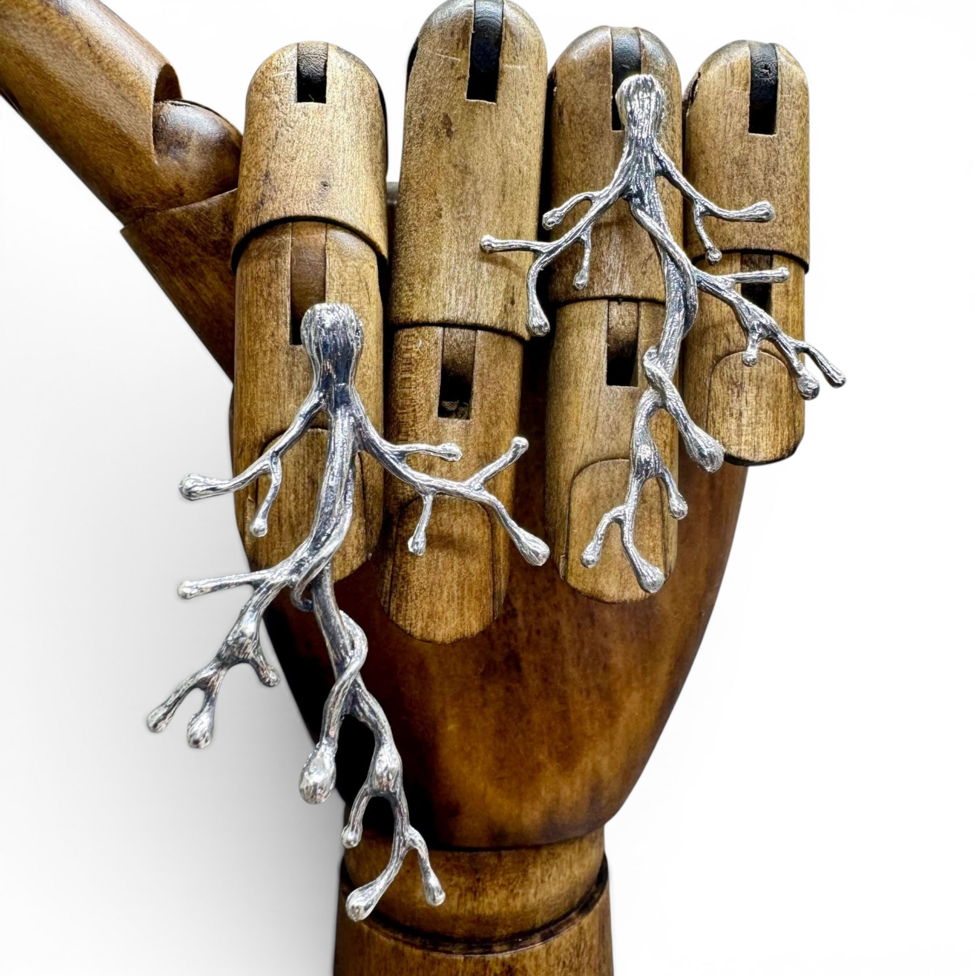 Ancient Woodland Branch Earrings handcrafted in sterling silver displayed on an artist’s wooden hand form