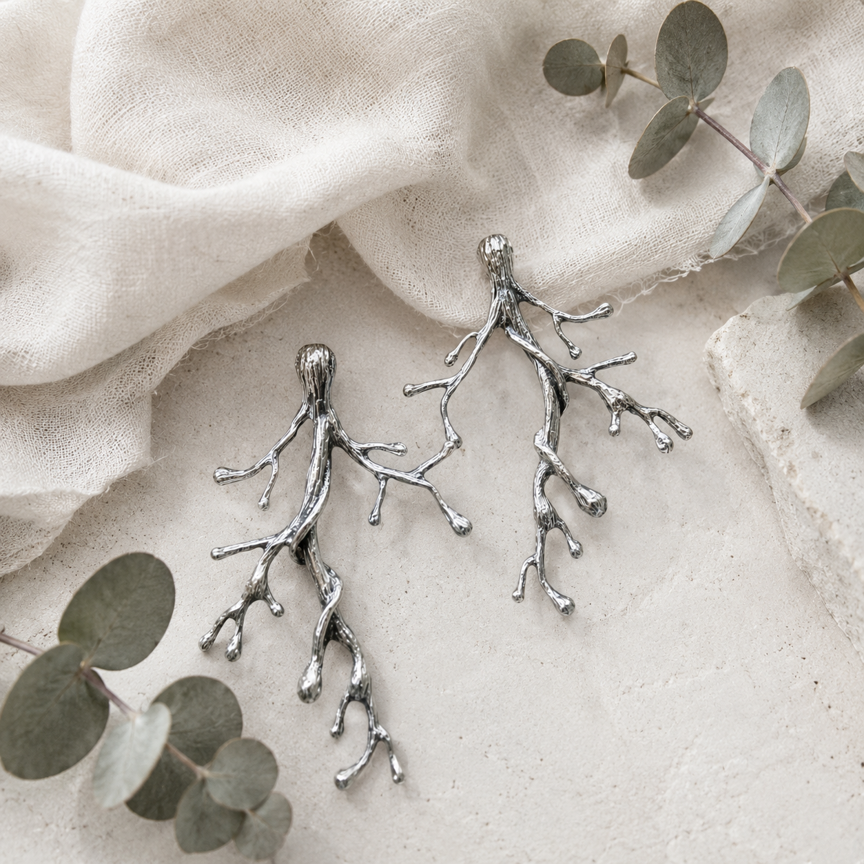 Ancient Woodland Branch Earrings in sterling silver styled on ivory linen with eucalyptus leaves and natural stone