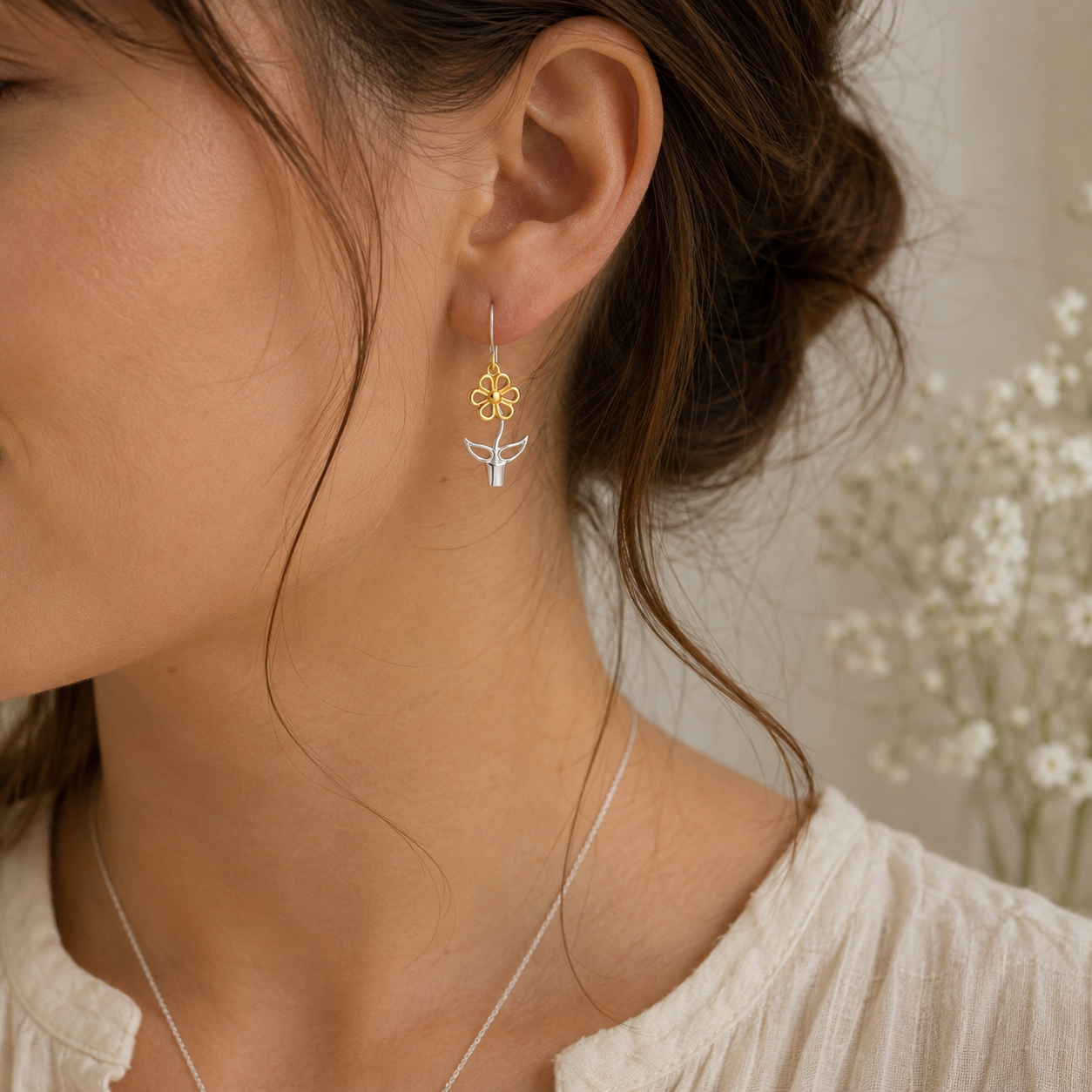 Woman wearing Blooming Joy flower pot drop earrings in sterling silver and gold with soft natural styling