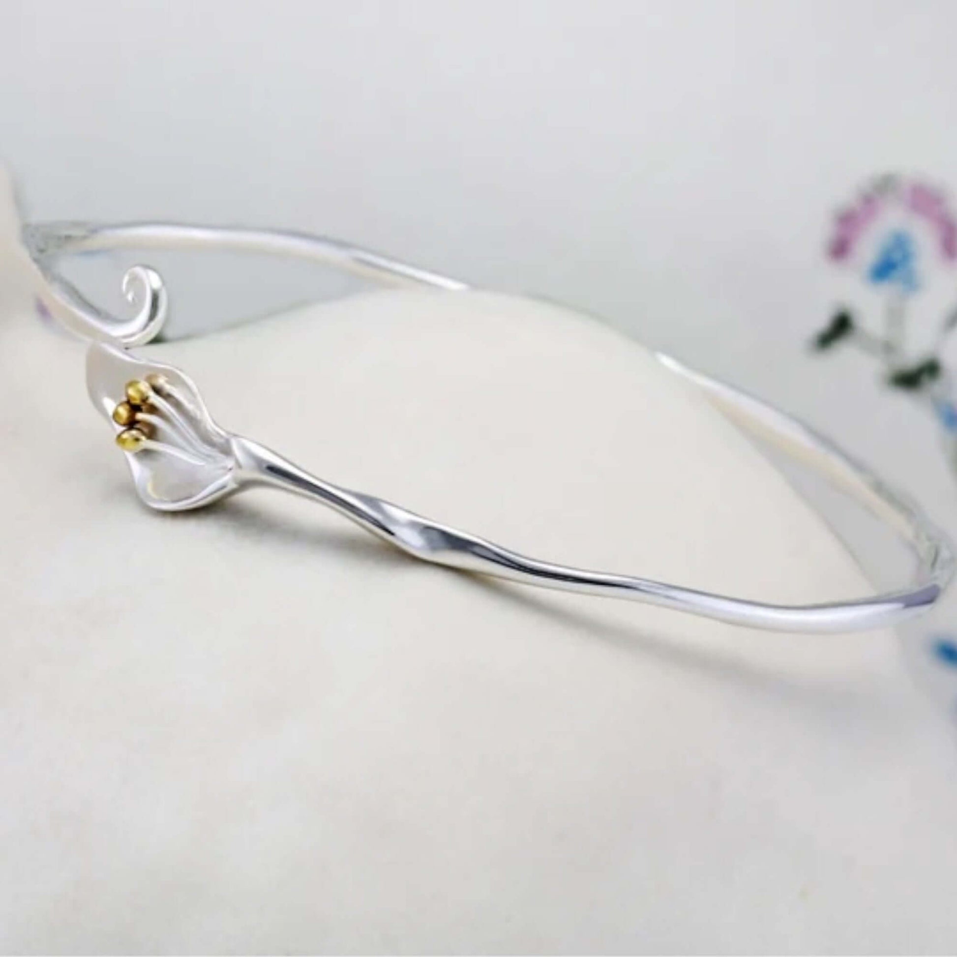 Front view of handcrafted Calla Lily floral bangle in sterling silver with gold detailing