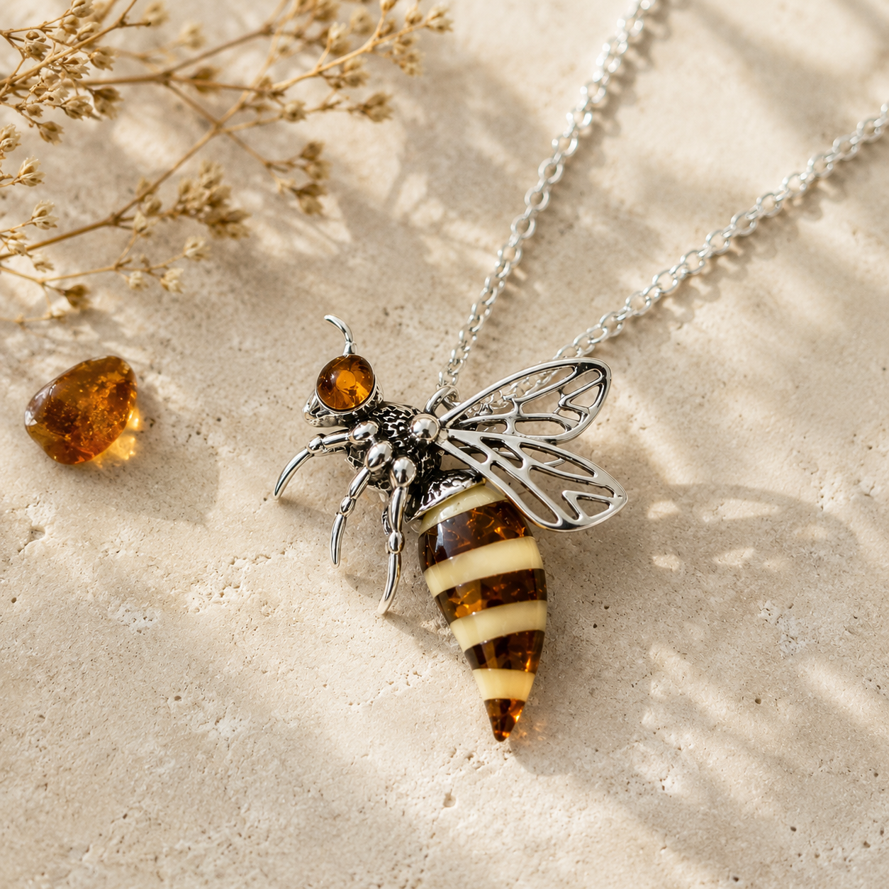 Classic Baltic amber bee pendant necklace styled in warm natural light with amber and botanical textures