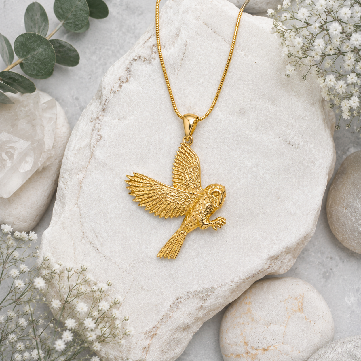 Twelve Silver Trees Jewellery Gold barn owl pendant necklace displayed on natural stone with botanical styling
