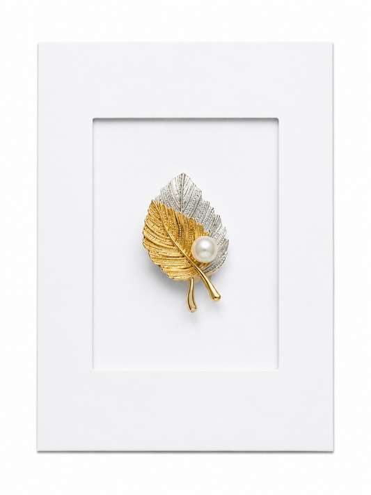 Keepsake brooch card featuring a two-tone gold and silver leaf brooch with pearl accent on a white display card