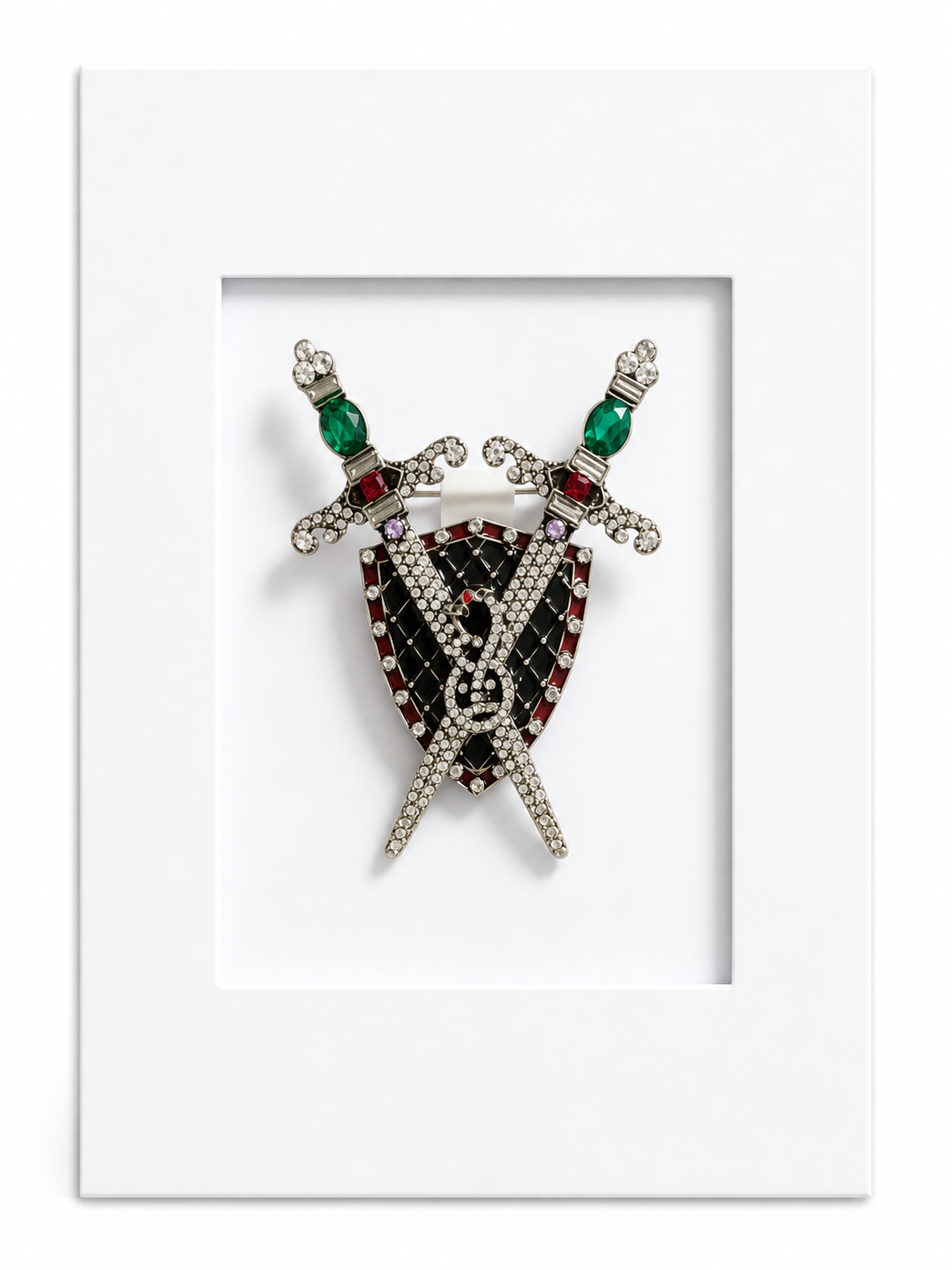 Statement keepsake card featuring a heraldic shield and crossed swords brooch mounted within a white presentation card.