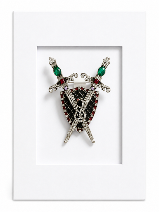 Statement keepsake card featuring a heraldic shield and crossed swords brooch mounted within a white presentation card.