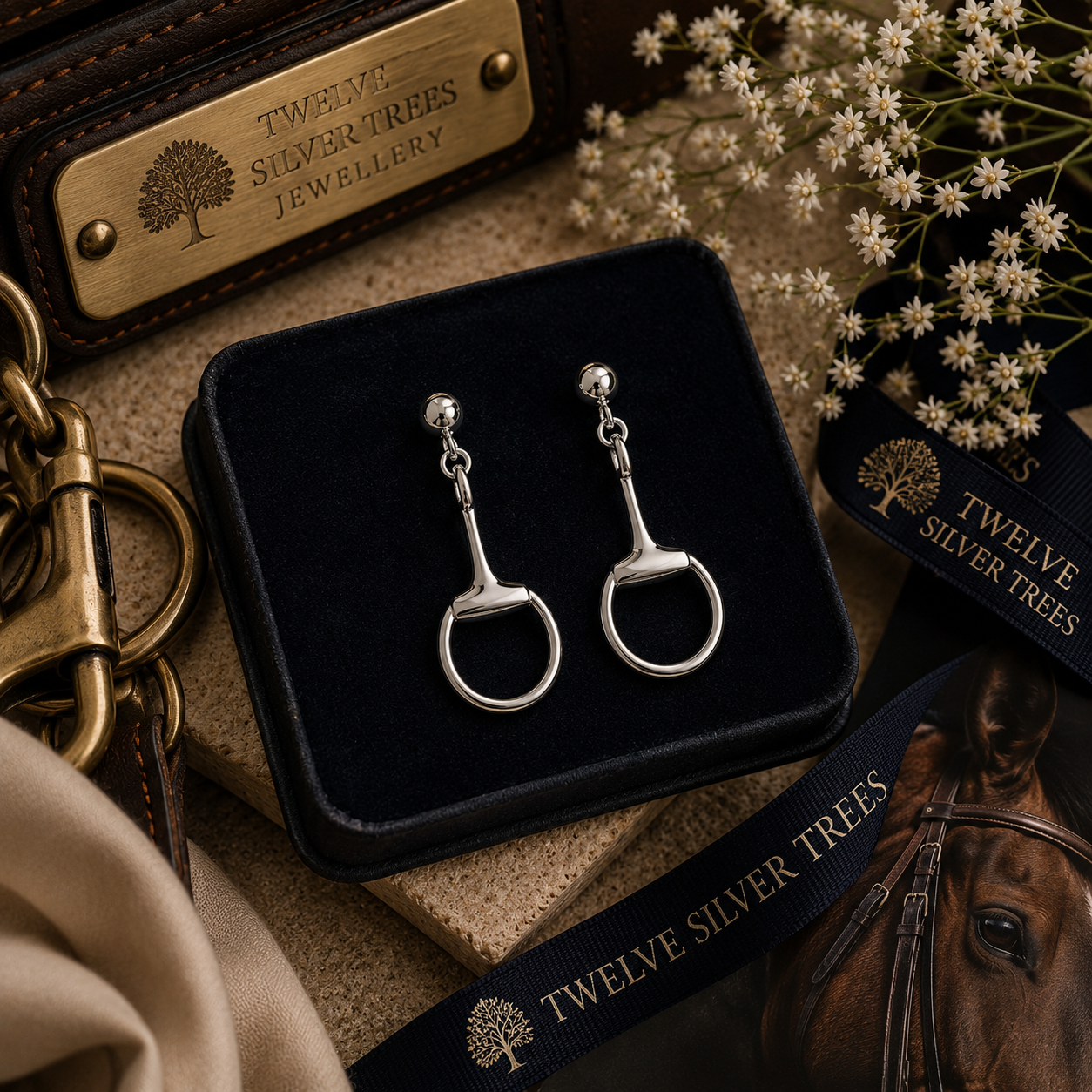 Luxury sterling silver snaffle drop earrings styled with equestrian leather accessories and velvet jewellery box