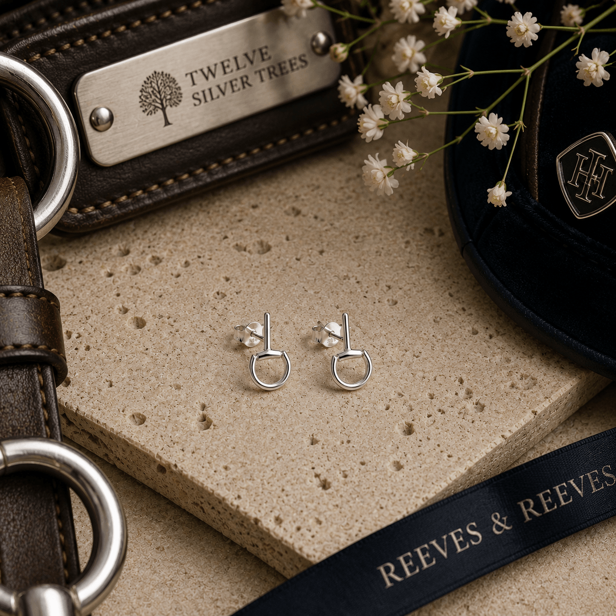 Mini sterling silver snaffle stud earrings styled with luxury equestrian leather accessories and refined neutral tones