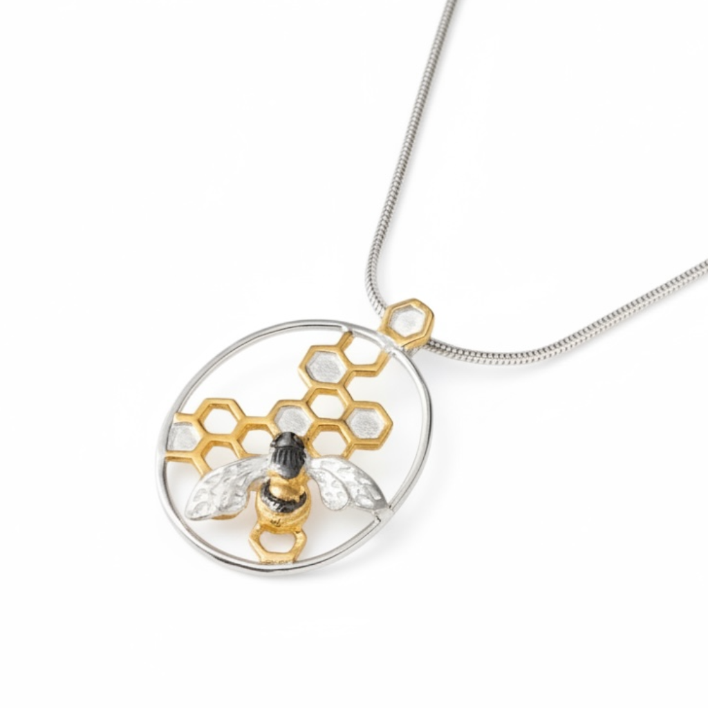 Handmade sterling silver bee and honeycomb pendant with 22ct gold vermeil honeycomb detail and black rhodium bee on a white background.