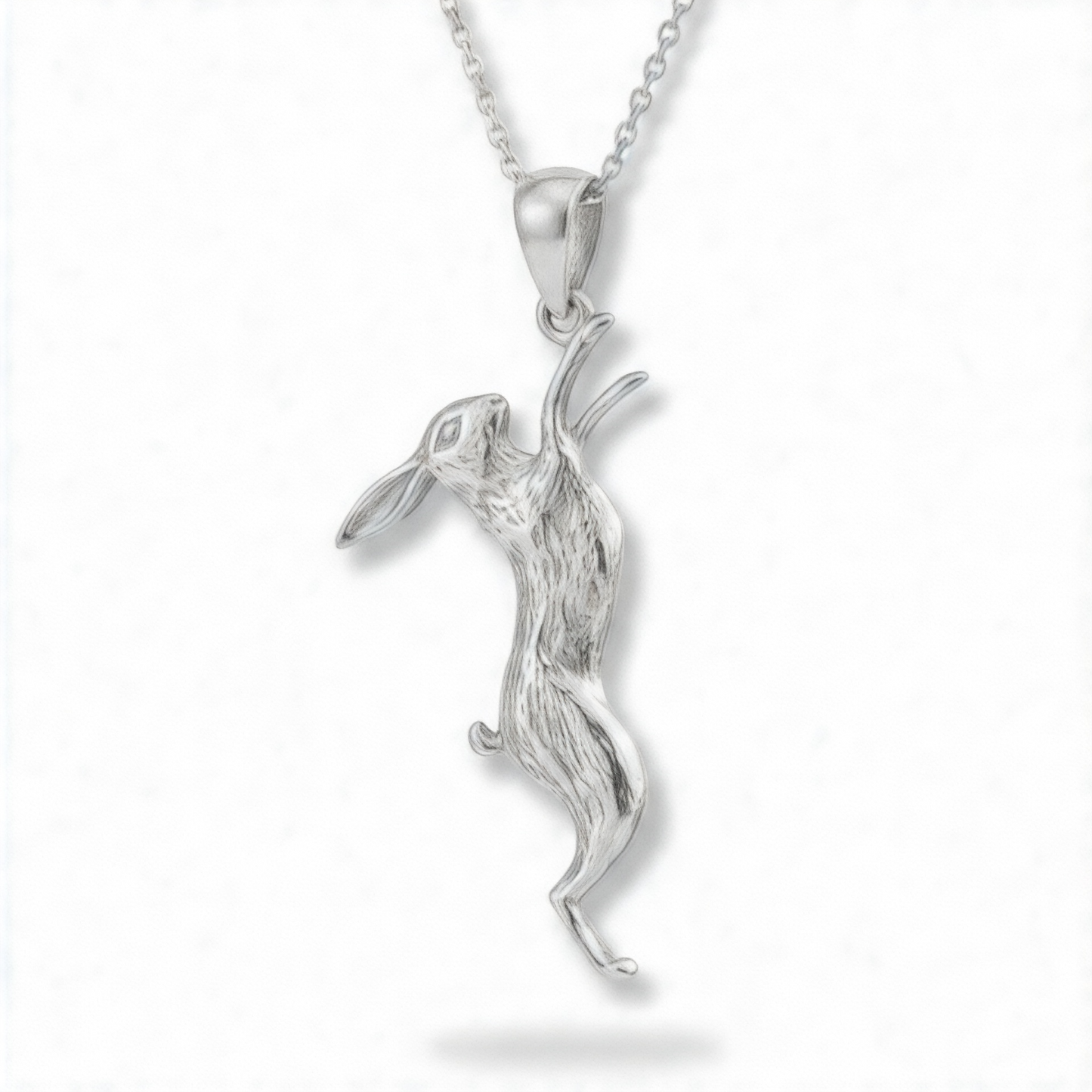 Handmade sterling silver March hare pendant necklace on a fine silver chain against a white background