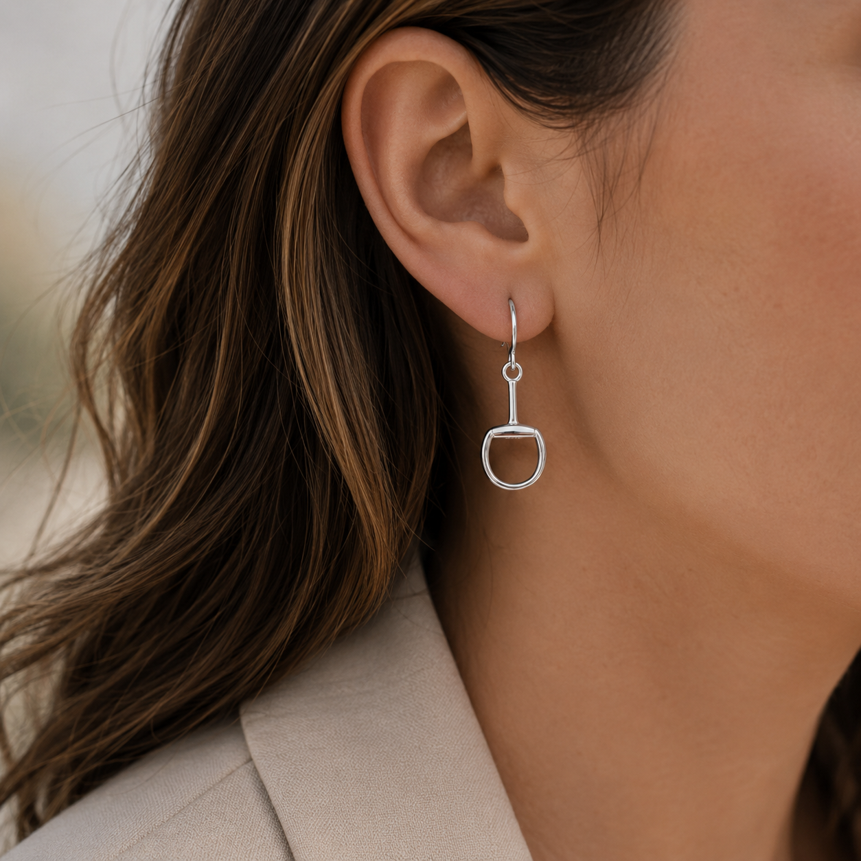 Model wearing sterling silver snaffle bit hook earrings inspired by classic equestrian tack