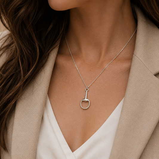 Woman wearing sterling silver single snaffle pendant necklace with elegant neutral styling