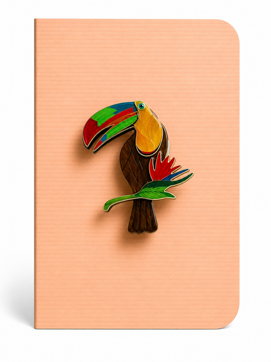 Colourful toucan keepsake card featuring a tropical bird brooch mounted on a blush peach textured greeting card.
