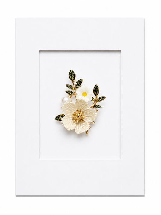 Keepsake brooch card featuring a delicate white flower brooch with pearl accents and green leaves on a white display card